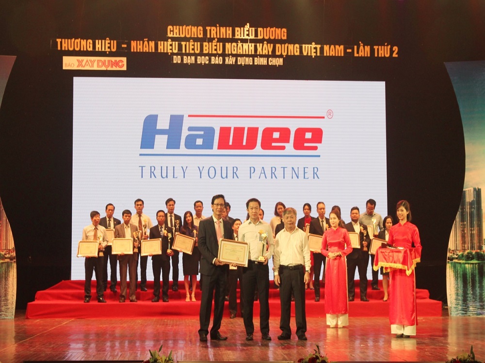 Ông Lê Vũ Long (giữa)- Giám đốc CTCP Hawee Cơ điện  lên nhận giải thưởng từ Thứ trưởng Bộ Xây dựng- Ông Nguyễn Đình Toàn (trái)